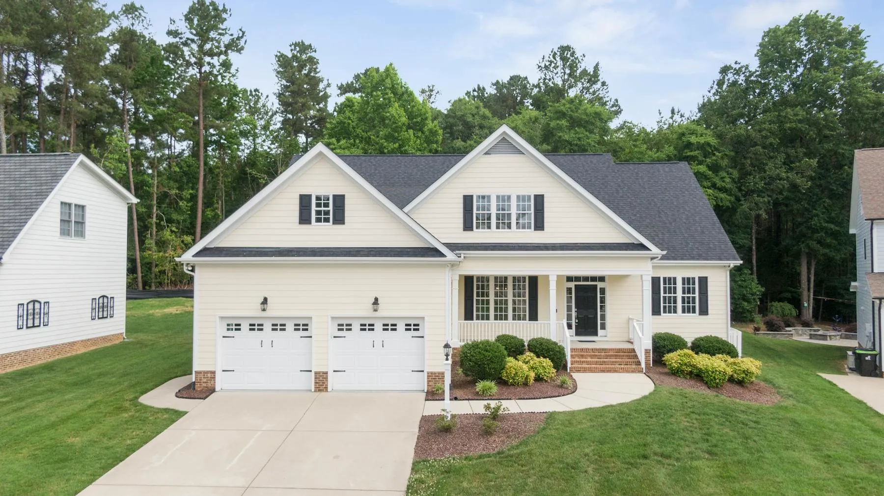 Freshly maintained suburban home exterior with bright trim, clean siding, and a polished driveway approach.