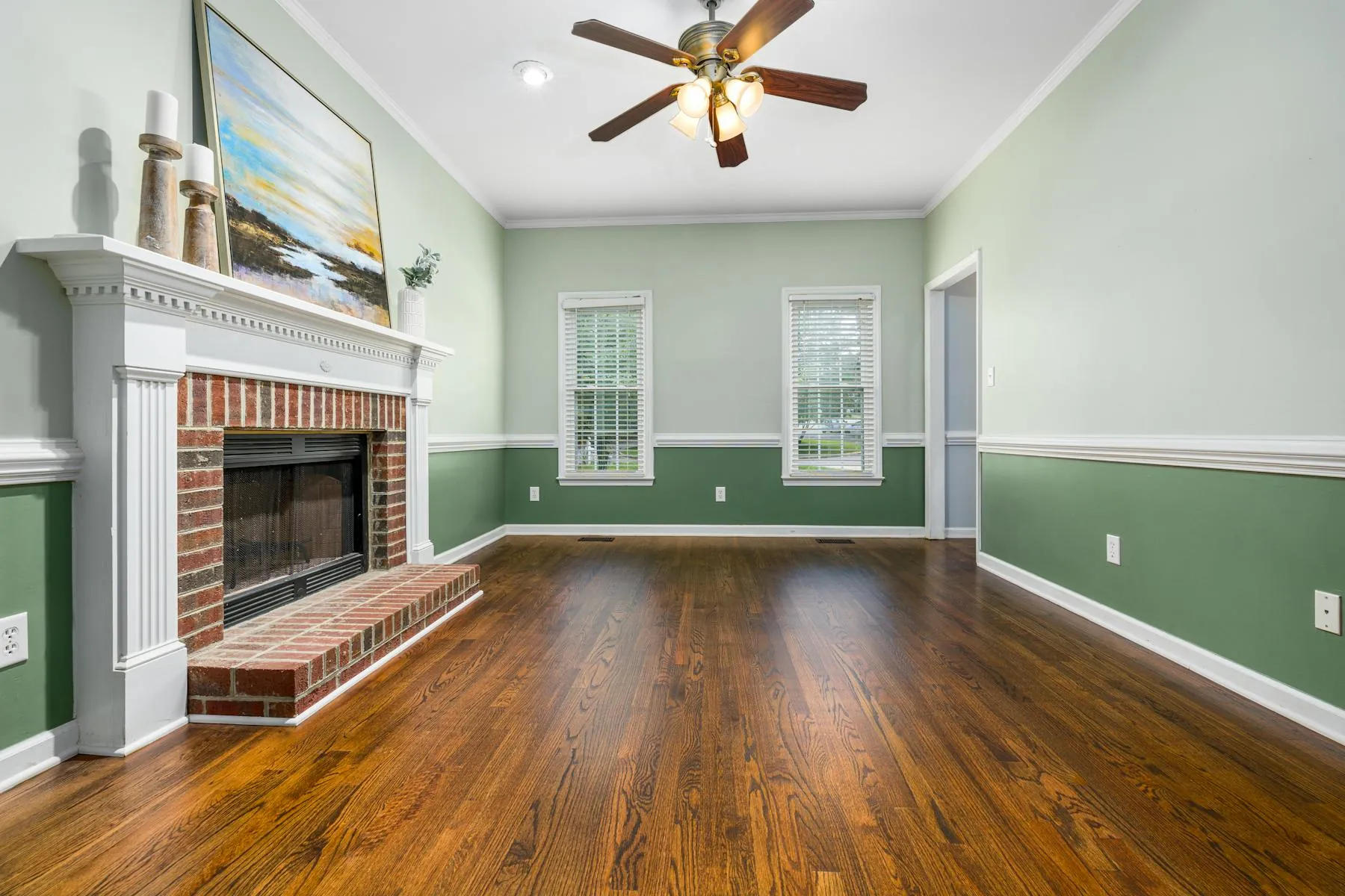 Freshly painted modern living room with soft blue accent wall and dark hardwood floors.