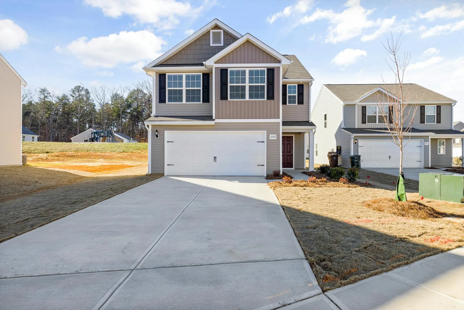 Clean suburban driveway and front approach beside a freshly maintained home exterior.